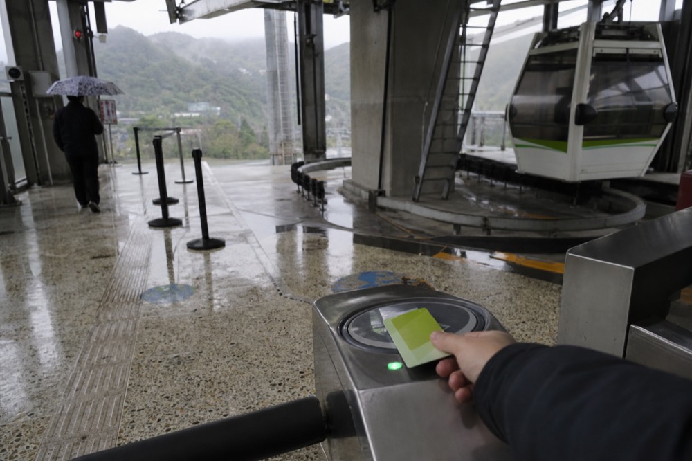 A visitor buying a transit card at an MRT station machine in Taipei, no text, no logos, no people