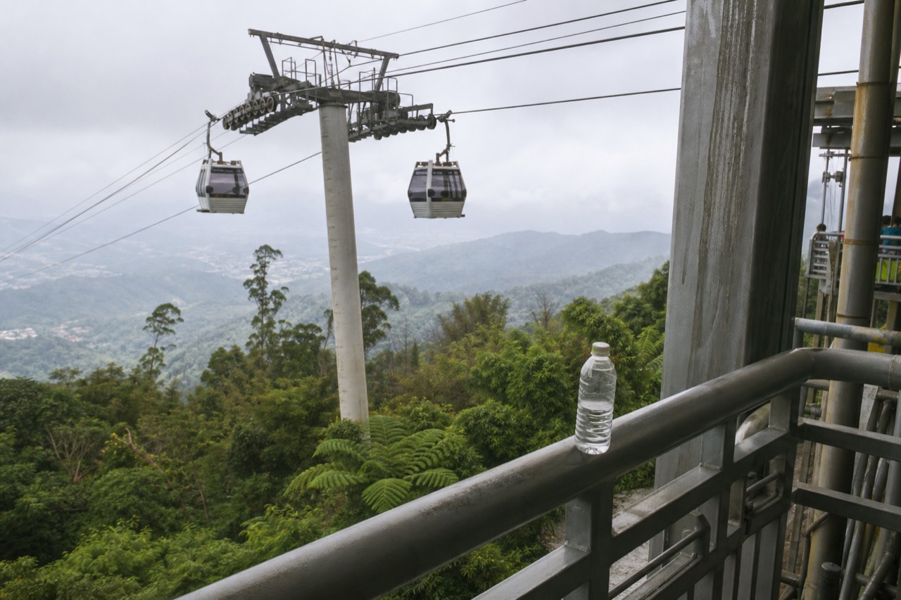 Gondola cabins travelling along a cable above forested hills near Taipei, no text, no logos, no people