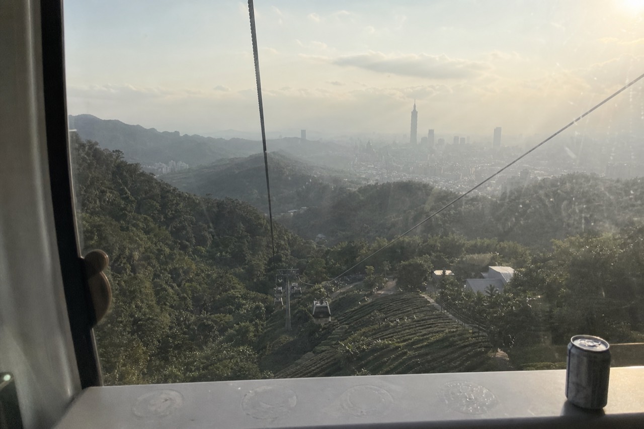 Maokong Station platform with Taipei city skyline in the distance, no text, no logos, no people