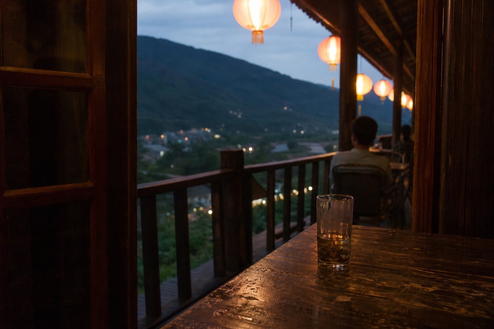 A teahouse terrace with lanterns and valley views in the evening, no text, no logos, no people