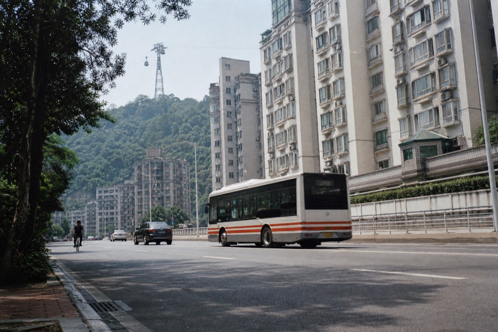 Maokong Tour Bus parked at a mountain roadside stop among trees, no text, no logos, no people