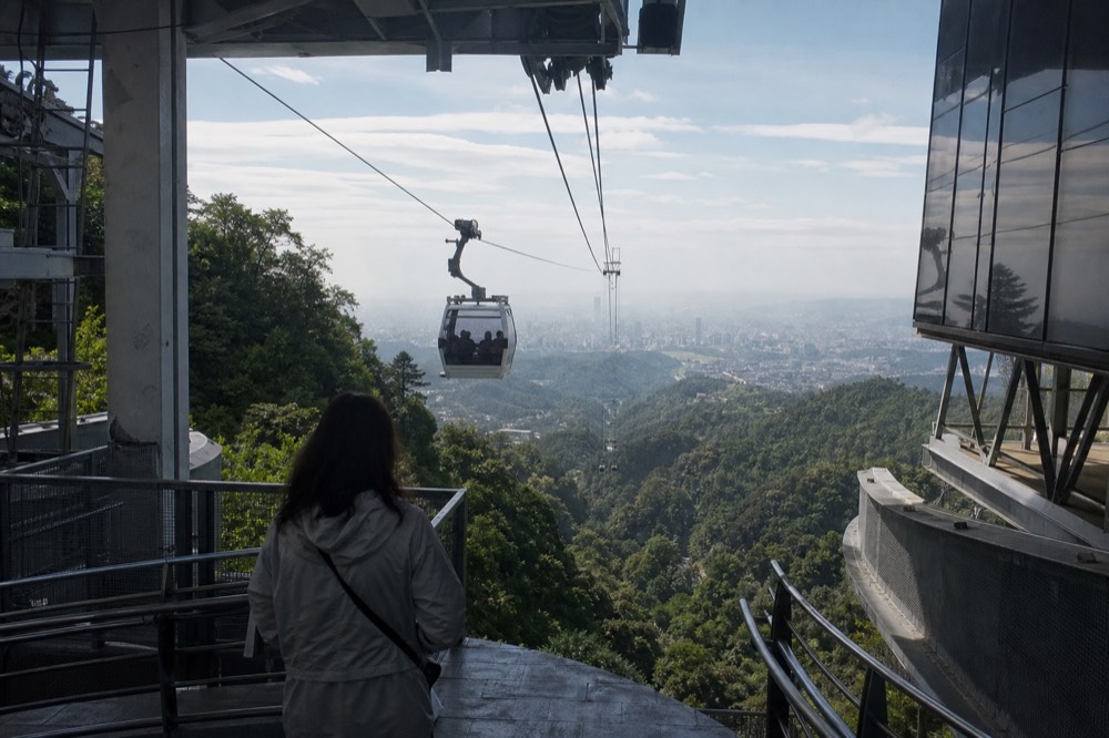 View from a gondola station platform over the Taipei basin at late afternoon, no text, no logos, no people