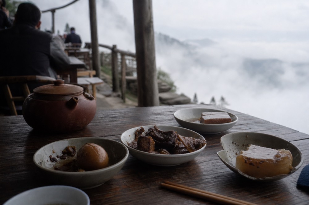 Small dishes and a teapot sharing a table on a terrace, no text, no logos, no people