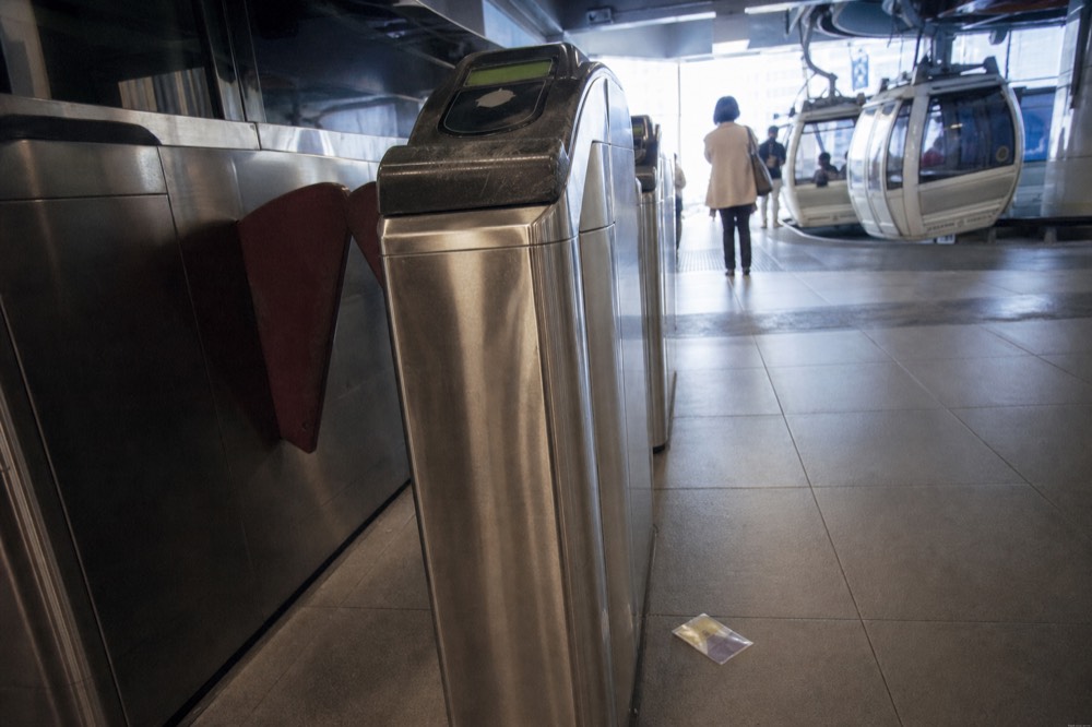 Ticket machines and gates at a gondola station platform, no text, no logos, no people