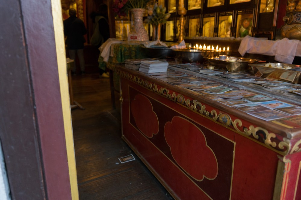 Prayer cards and offerings at a temple counter with red and gold decoration, no text, no logos, no people