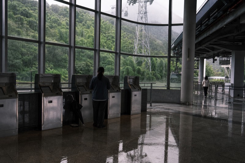 Ticket machines and a fare board inside the bottom station concourse, with no readable text.